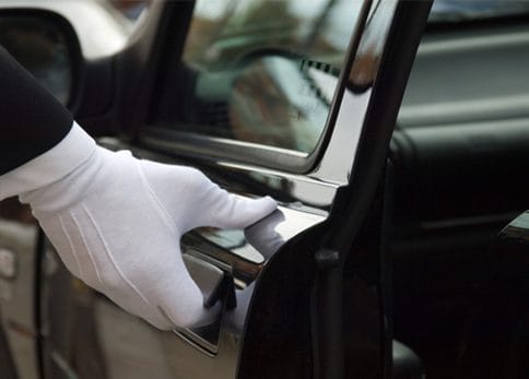 A gloved hand opening a limo door