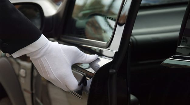 A gloved hand opening a limo door